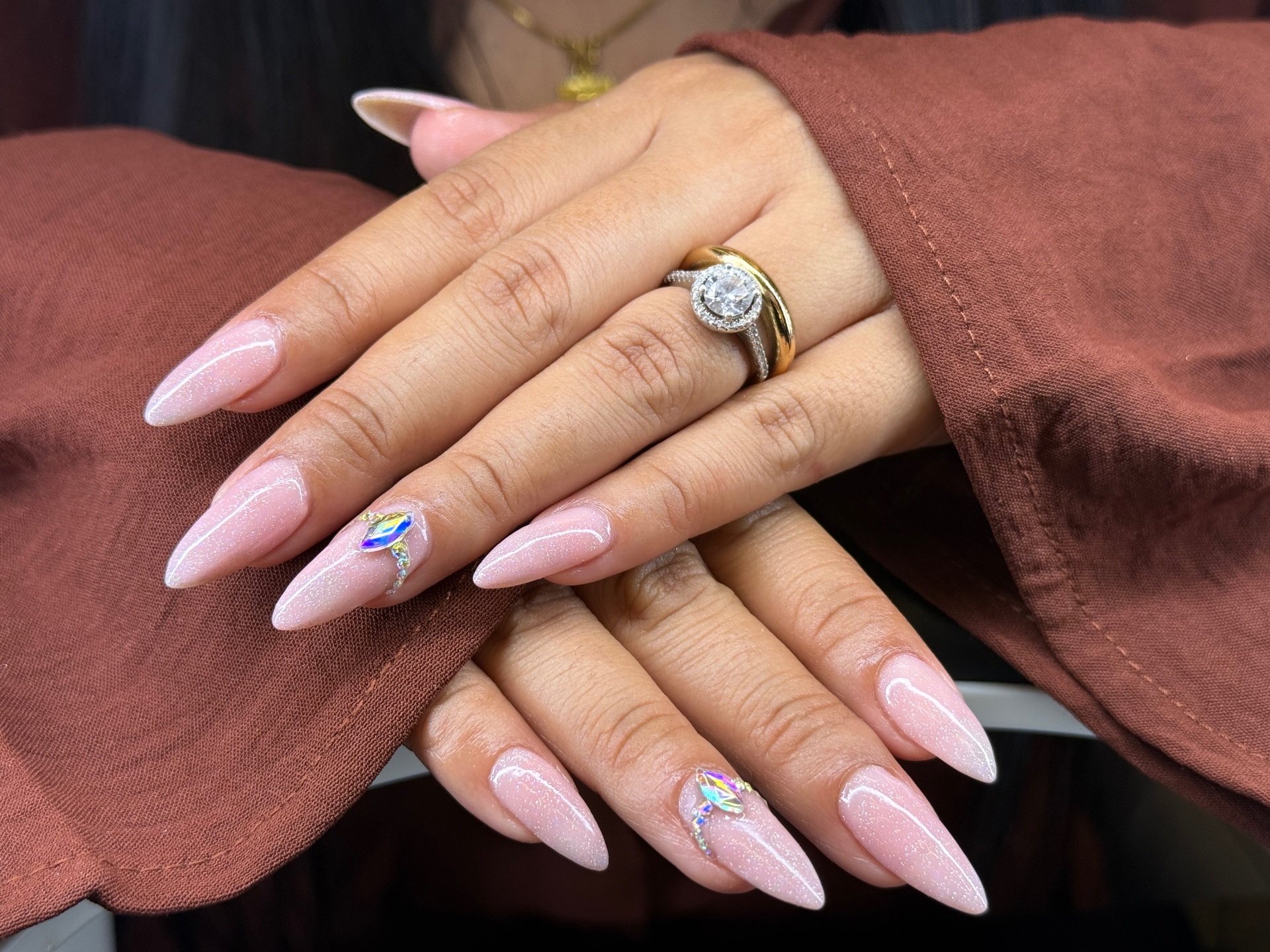 Pink shimmer stiletto nails with crystal accent